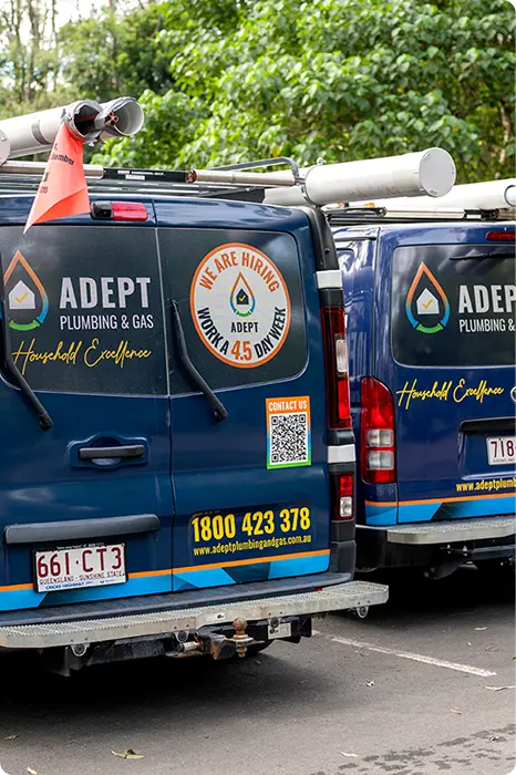 Two Adept Plumbing & Gas branded work vans parked side by side