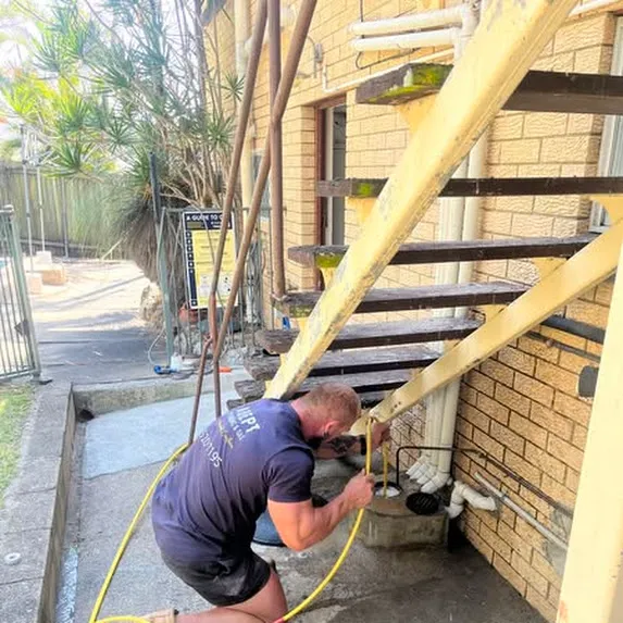 Licensed plumber in Logan clearing a minor blockage in the bathroom drain
