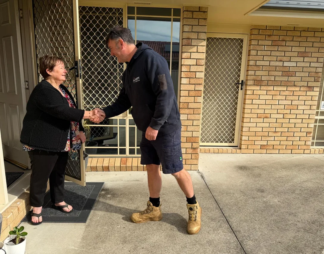 Adept Plumbing & Gas plumber greeting a customer at her front door