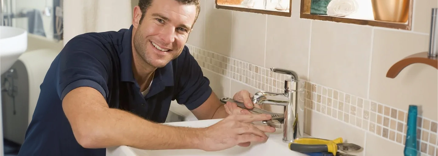 Plumber replacing a bathroom basin tap