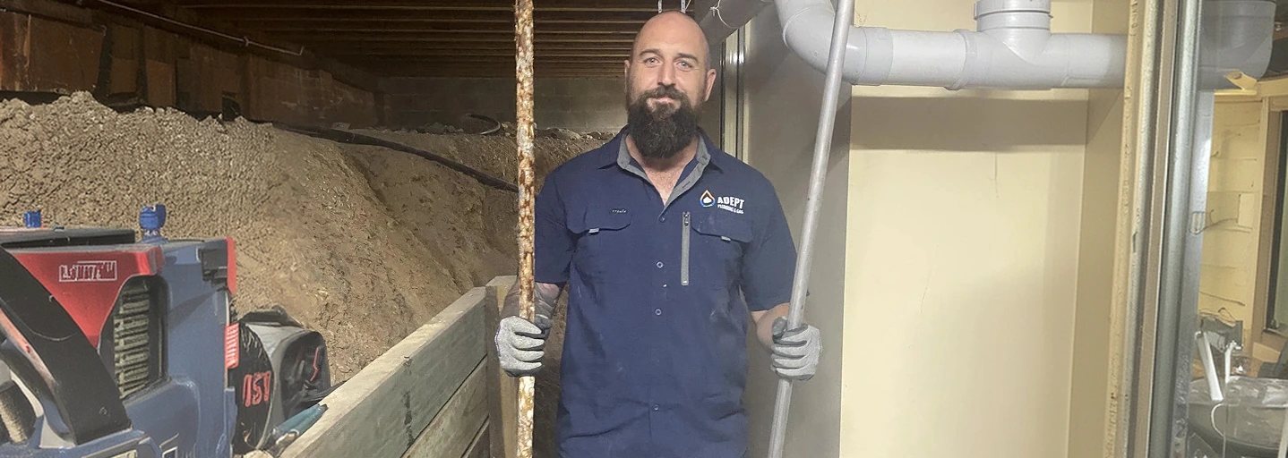 Adept Plumbing & Gas technician holding a corroded sacrificial anode rod