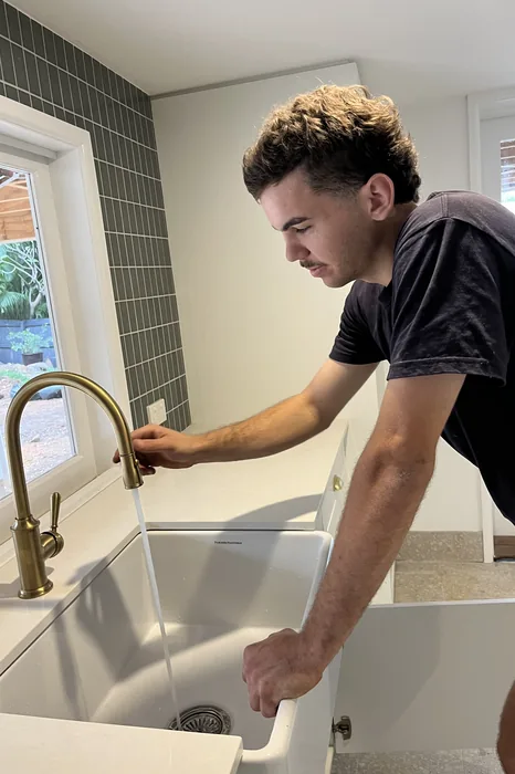 Plumber installing a laundry tap in a new home