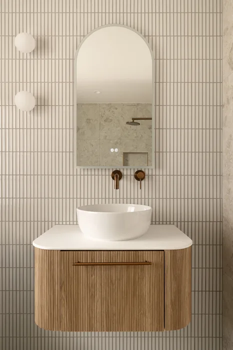 Finished bathroom with a timber vanity, round basin and brass tapware