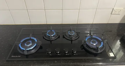 Gas cooktop with the burners lit in a Calamvale kitchen
