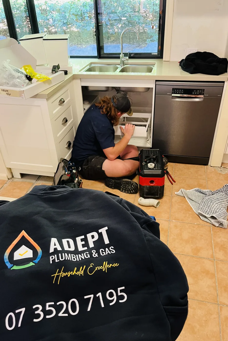 Adept Plumbing & Gas plumber installing a dishwasher in a Daisy Hill kitchen
