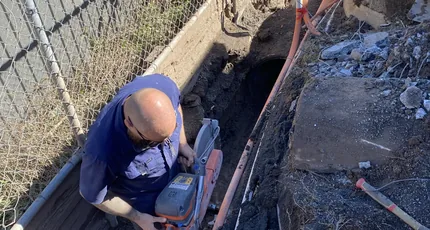 Plumber repairing a drain in an excavated trench in Rochedale
