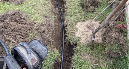 New pipe laid in a trench across a Shailer Park lawn