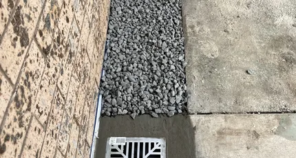 Strip drain and grate installed beside a paved area in Shailer Park