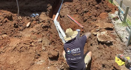 Adept Plumbing & Gas plumber working in a deep excavation beside a Tarragindi home