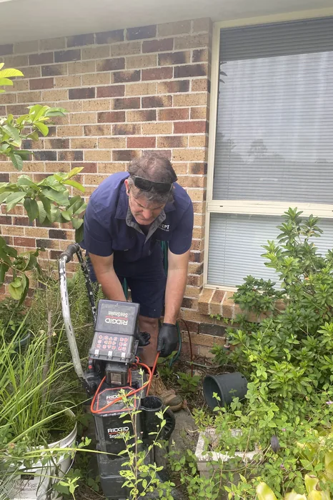 Adept Plumbing & Gas plumber working on an outdoor tap beside a Tarragindi home