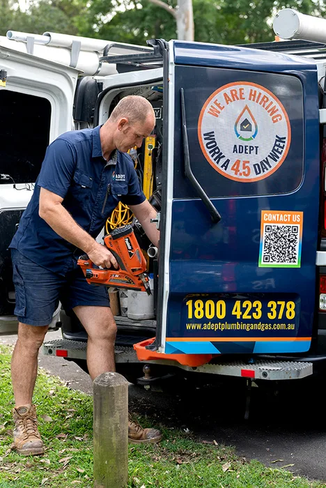 Adept Plumbing and Gas plumber unloading equipment from a branded service van