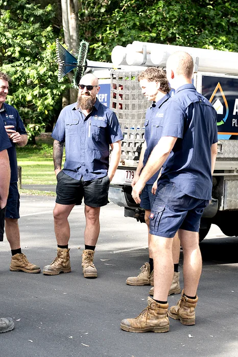 Adept Plumbing & Gas team gathered beside a company truck
