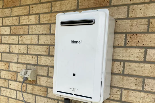 Rinnai instantaneous gas hot water system on a brick wall