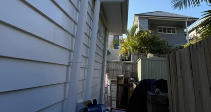 Downpipe on a weatherboard home with the neighbouring house behind in Carina