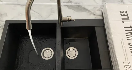 Black double kitchen sink with a stainless mixer in Carina