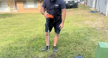 Plumber locating a leak in a front yard in Carina