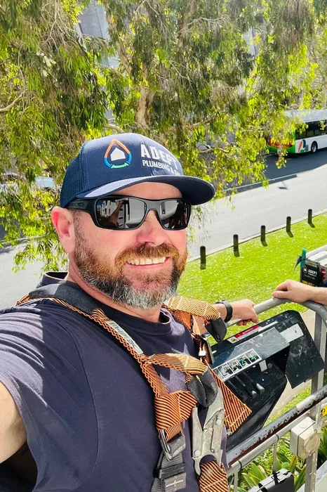 Adept Plumbing & Gas plumber working from an elevated platform in Carindale
