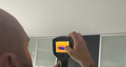 Plumber using a thermal imaging camera to find a leak in Cornubia