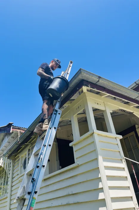 Adept Plumbing & Gas plumber working at roof level on a Greenslopes home