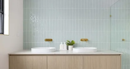 Double vanity with brass wall-mounted tapware in a Holland Park bathroom