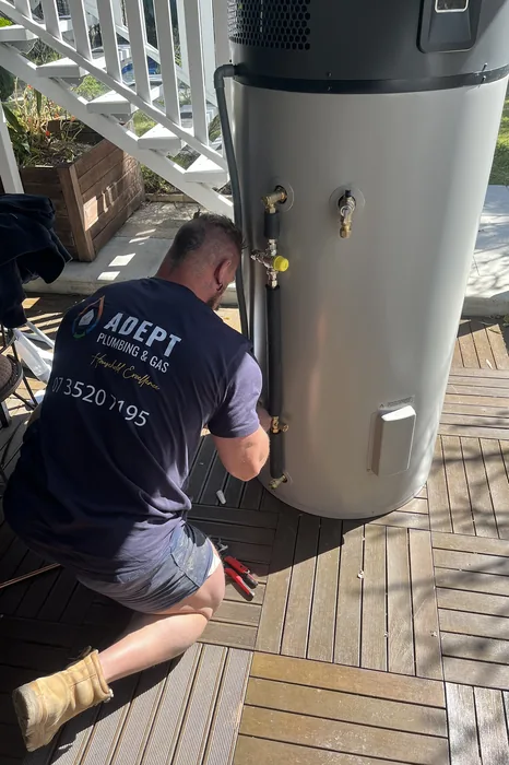 Adept Plumbing & Gas plumber installing a heat pump hot water system in Holland Park