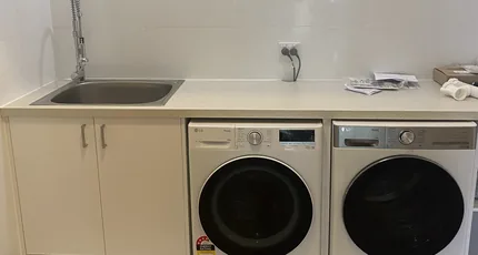 Laundry sink and washing machine plumbing in a Holland Park home