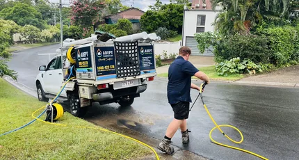 Plumber jetting a drain from the service ute on a Kingston street