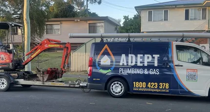 Adept Plumbing & Gas van towing a mini excavator in Kingston