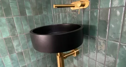 Black basin with brass wall tapware in a Loganholme powder room