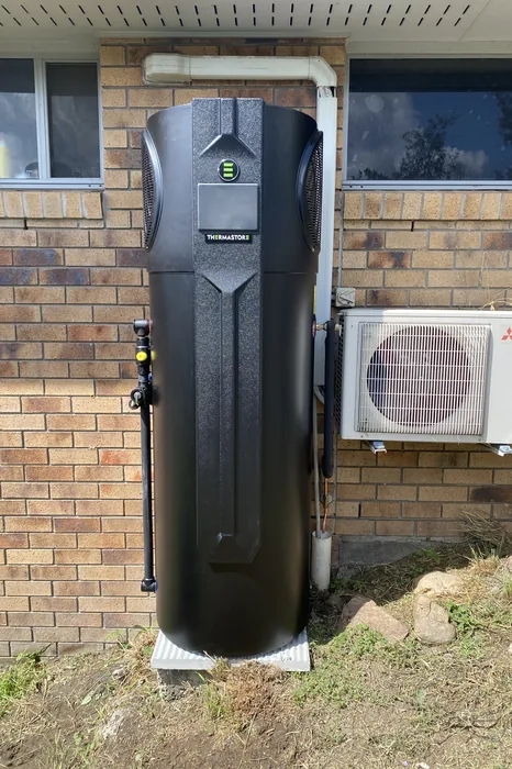 Heat pump hot water system installed against a brick home in Marsden