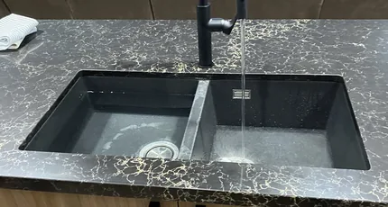 Black double kitchen sink with a matte black mixer in Marsden