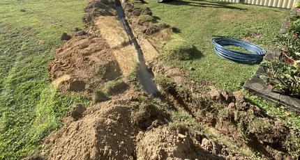Trench dug across a yard for new pipework in Meadowbrook