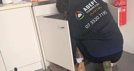 Plumber working under a kitchen sink in Meadowbrook
