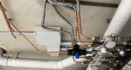 Copper and PVC pipework with water meters in a New Farm building