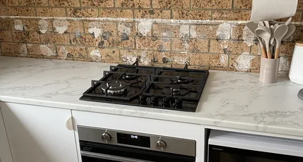 Kitchen with a gas cooktop and wall oven in New Farm