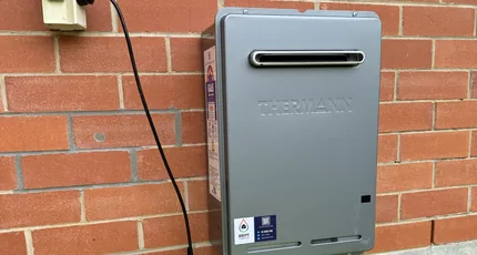 Continuous flow gas hot water system on a brick wall in Rochedale
