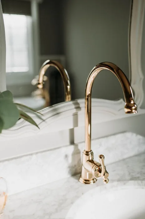 Brass kitchen mixer over a marble benchtop in Springwood