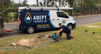 Plumber jetting a drain beside the Adept Plumbing & Gas van in Springwood