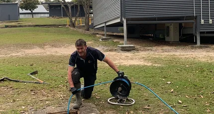 Plumber clearing a sewer through an access point in Springwood