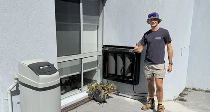 Plumber beside a newly installed water filtration system in Springwood