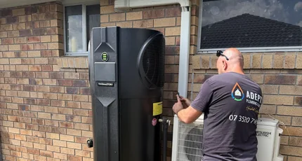 Plumber installing a heat pump hot water system in Waterford