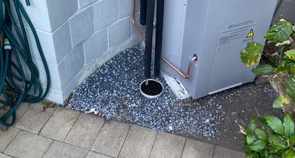 Hot water drain line and downpipe beside a home in Waterford