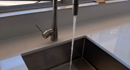Black kitchen mixer over an undermount sink in West End