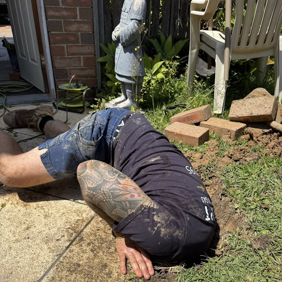 24-hour emergency plumber digging hole to find a leaking pipe in Logan